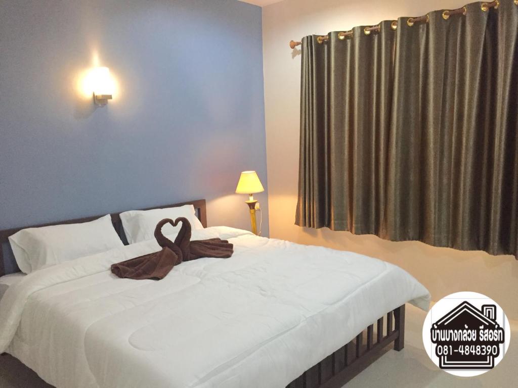 ein Schlafzimmer mit einem Bett mit einem braunen Band darauf in der Unterkunft Baan Bang Kluai Resort บ้านบางกล้วย รีสอร์ท in Surat Thani