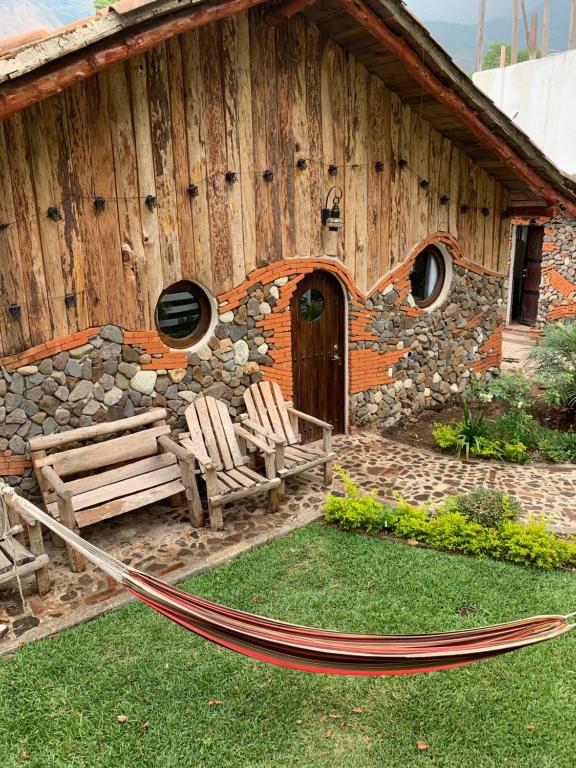 a building with a hammock in front of it at Cabañas de Tzununa in Tzununá