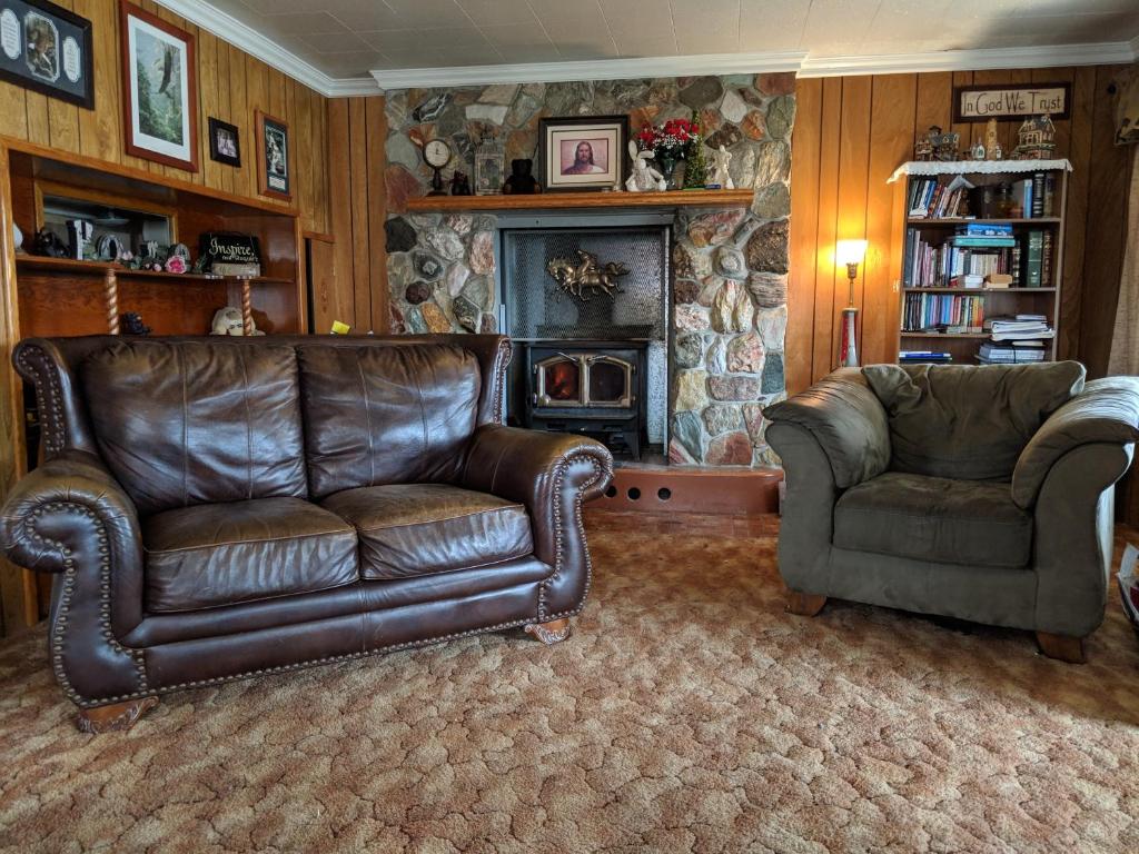 a living room with two leather couches and a fireplace at Three Bears Inn in Saint Anthony