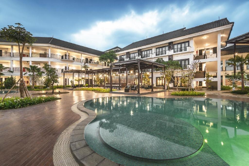 un patio con piscina frente a un edificio en Lido Lake Resort by MNC Hotel, en Bogor