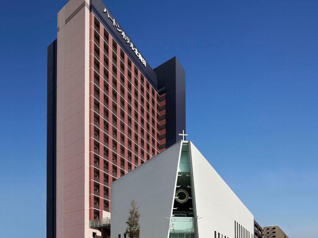 um edifício alto com uma igreja em frente em Hearton Hotel Kita Umeda em Osaka