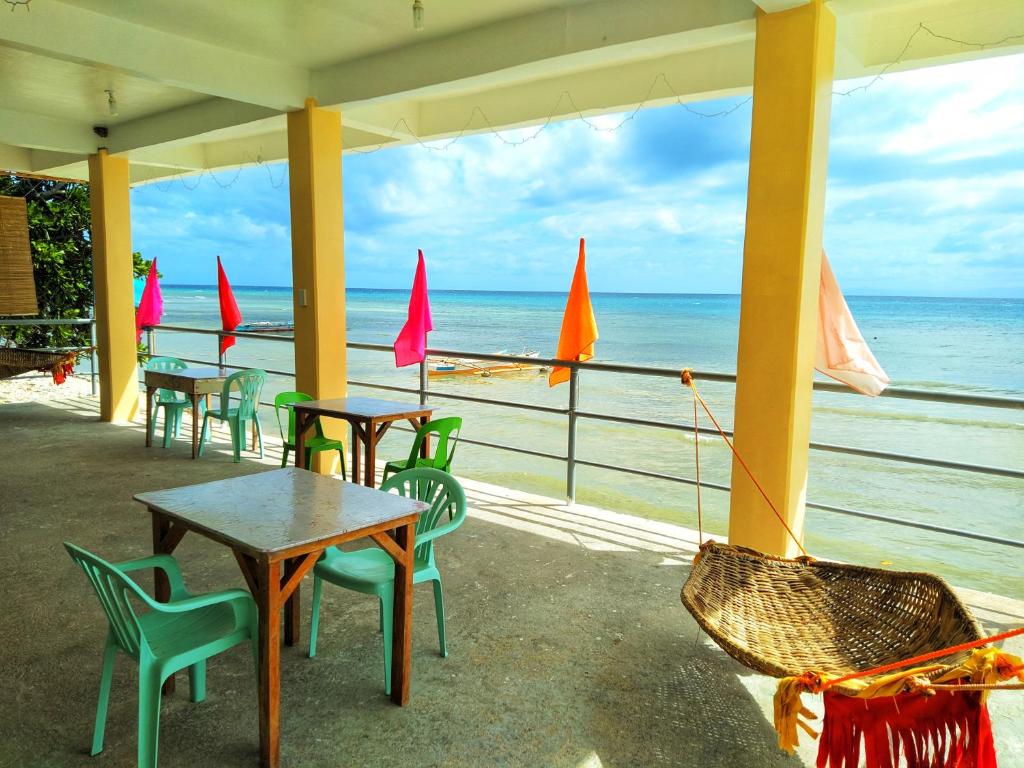 uma fila de mesas e cadeiras na praia em Ocean View Lodging House em Oslob