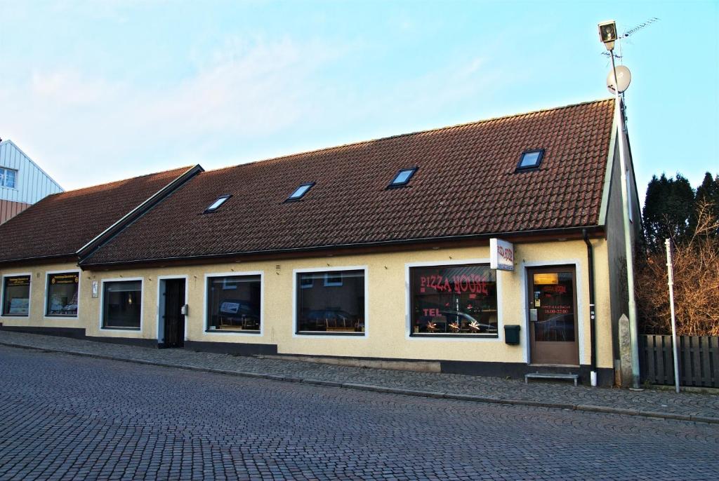 un edificio con tetto marrone su una strada di Pizza House Bed Simrishamn a Simrishamn