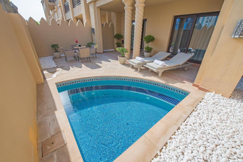 a swimming pool in the middle of a yard at Luxurious 3BR Townhouse with Maid's & Private Pool in Palm Jumeirah in Dubai