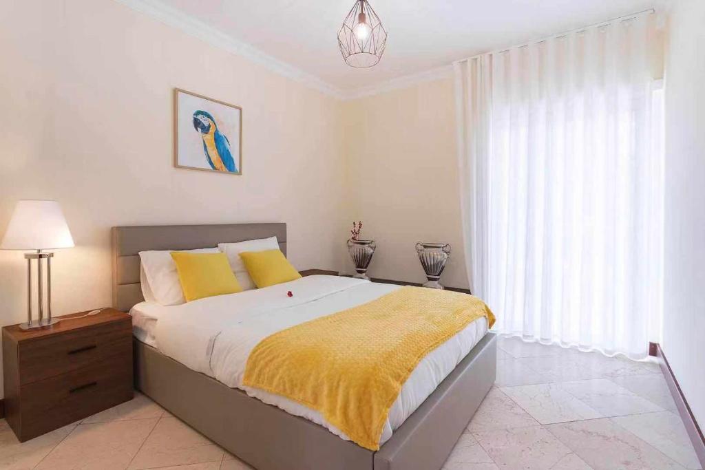 ein Schlafzimmer mit einem großen Bett und einer gelben Decke in der Unterkunft Heart of Ocean Dulpex Estoril in Estoril