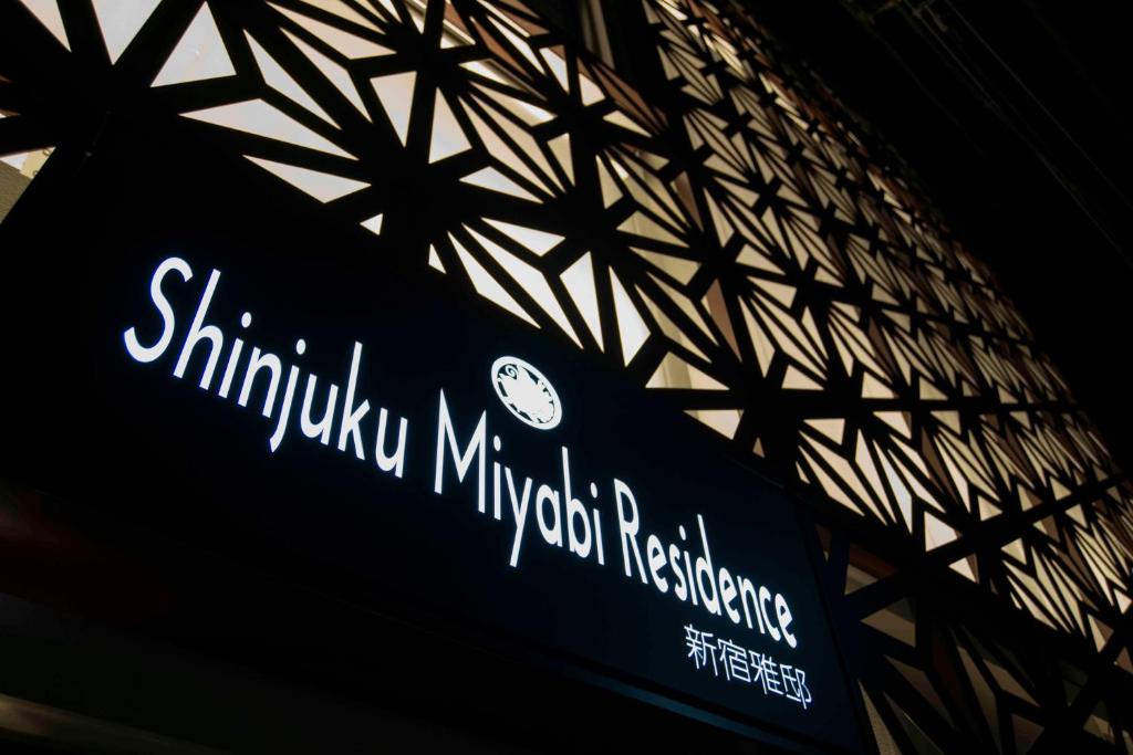 a sign for a subway station with a clock on it at Shinjuku Miyabi Residence in Tokyo