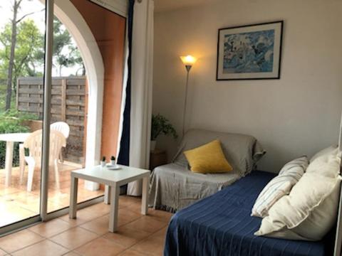 a room with a bed and a couch and a table at 50m Plage T2 Grande Terrasse Vue Mer Climatisé Piscine Chauffée, Parking clos gratuit in Sanary-sur-Mer