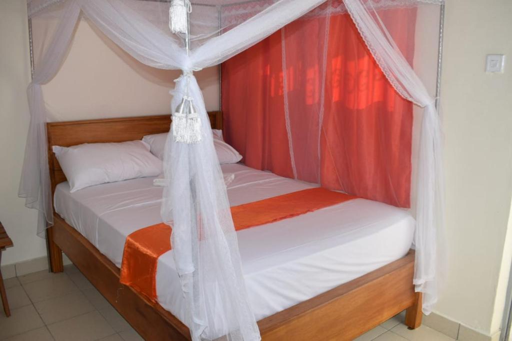 Marya Shelters Limited في مومباسا: غرفة نوم بسرير مع مظلة