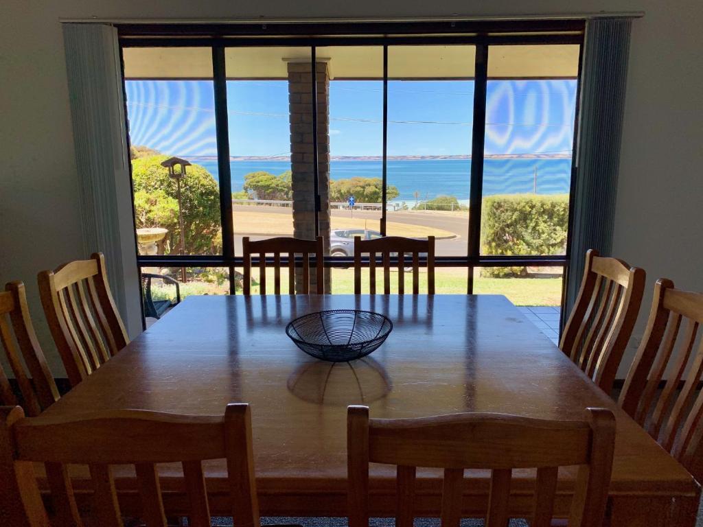 a dining room table with a view of the ocean at Beachside House in Kingscote