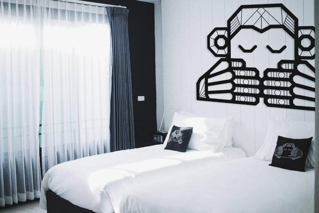 ein Schlafzimmer mit 2 Betten und ein Schild an der Wand in der Unterkunft Blu Monkey Phi Phi Island in Ko Phi Phi