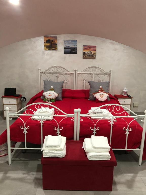 sypialnia z czerwonym łóżkiem i ręcznikami w obiekcie A'CASA E' MAMMA' w mieście Neapol
