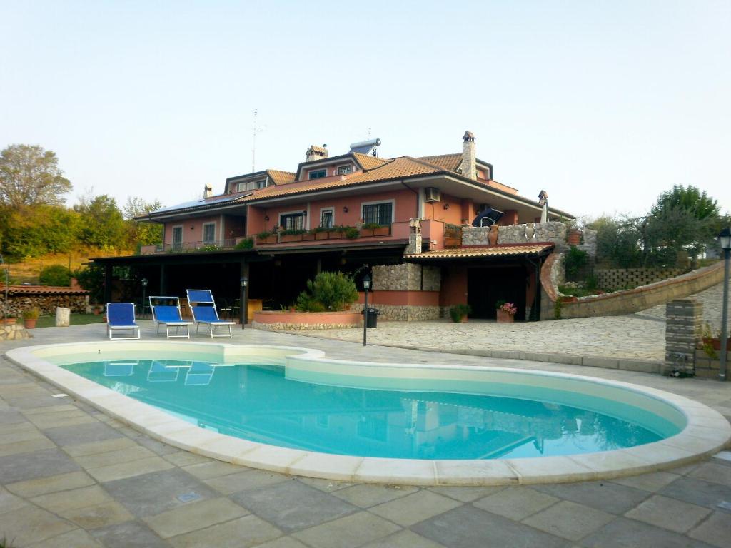 una casa con piscina di fronte a una casa di Alla Quercia a Monterotondo