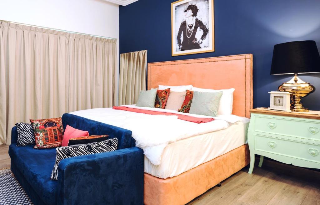 a bedroom with a large bed with a blue wall at Near Burj Khalifa, DownTown - Burj Al Nujoom in Dubai