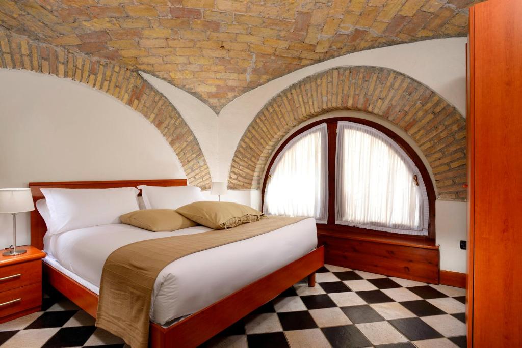 1 dormitorio con 1 cama con pared de ladrillo en Roma Resort Termini, en Roma
