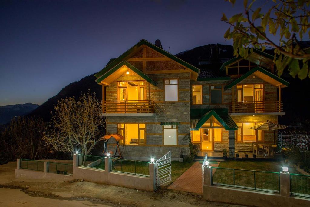 a house at night with its lights on at Stonehurst Cottage - Mountain-facing Heavenly Abode in Manāli