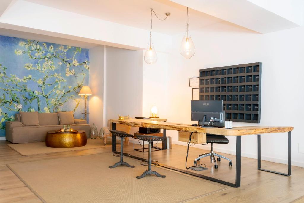 a living room with a desk with a computer on it at Can Beia Hostal Boutique in San Antonio