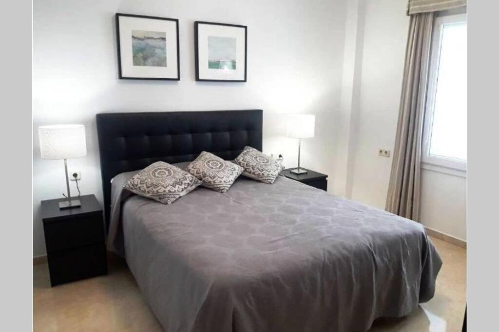 een slaapkamer met een groot bed met kussens erop bij Coqueto Apartamento en el Arenal, Centro in Sevilla