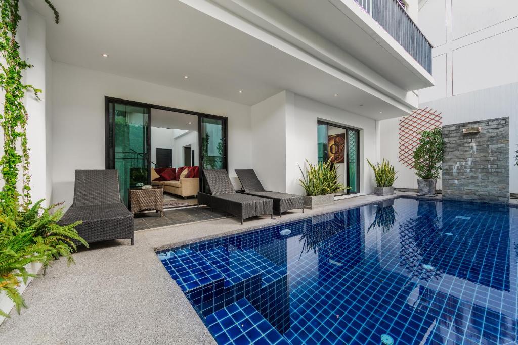 una piscina in una villa con piastrelle blu di Thaimond Residence by TropicLook a Nai Harn Beach