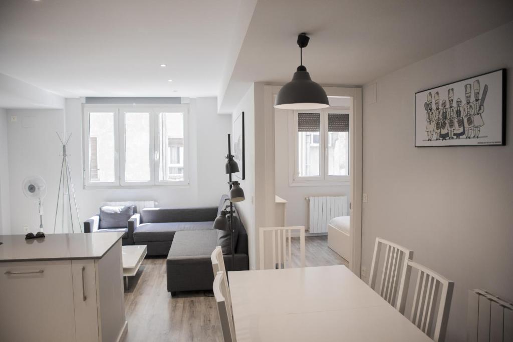 a kitchen and living room with a couch and a table at Plaza B - Local Rentss in San Sebastián