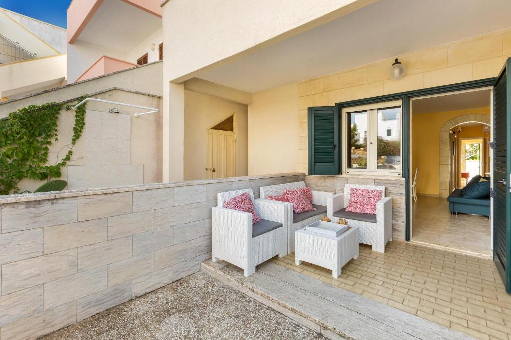 patio con sedie bianche e cuscini rosa di Casa Mya by BarbarHouse a Lido Marini