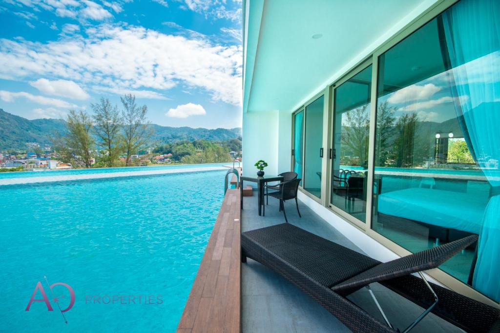 カマラビーチにあるLuxury Lagoon 1bedroom Apartmentの建物の隣にスイミングプール(テーブル、椅子付)