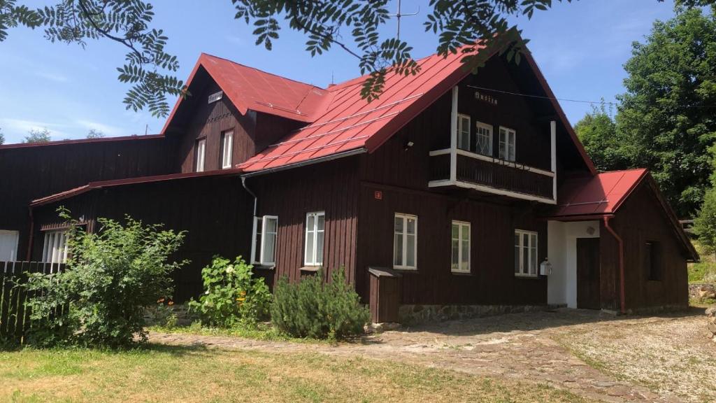 czarna stodoła z czerwonym dachem w obiekcie Belvederská chalupa w mieście Železná Ruda