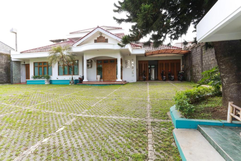 a house with a lawn in front of it at RedDoorz Syariah near Alun Alun Magelang Bayeman in Magelang
