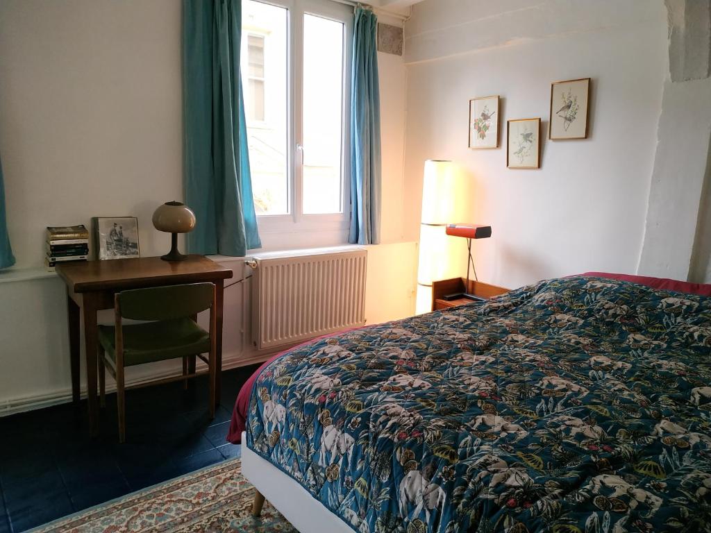 1 dormitorio con cama, escritorio y ventana en Maison hypercentre Rouen tout confort, en Rouen