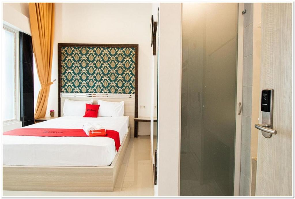 una camera con letto e doccia in vetro di RedDoorz Plus @ Centrium Katamso Medan a Medan