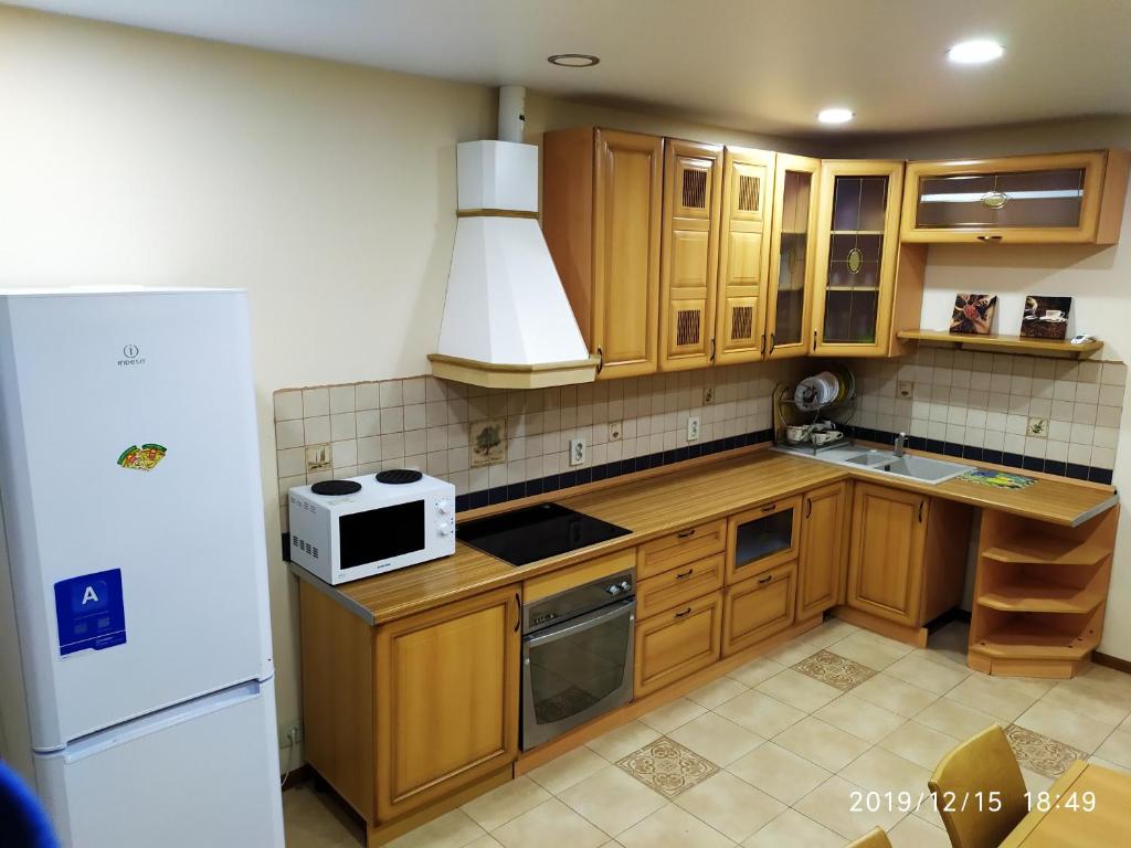 a kitchen with wooden cabinets and a white microwave at Новая двухкомнатная квартира в центре Воронежа. in Voronezh