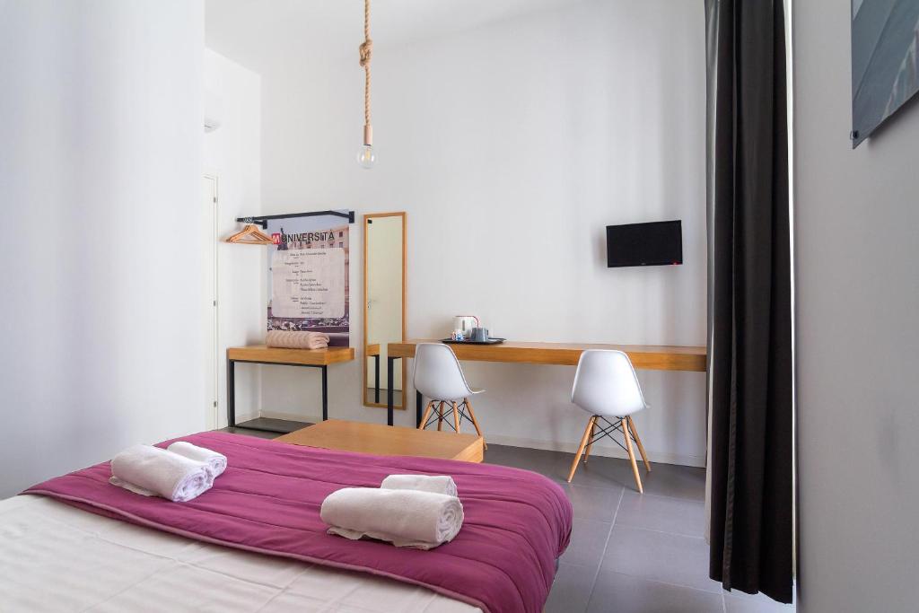 1 dormitorio con 1 cama con 2 toallas en Maison du La Metro, en Nápoles
