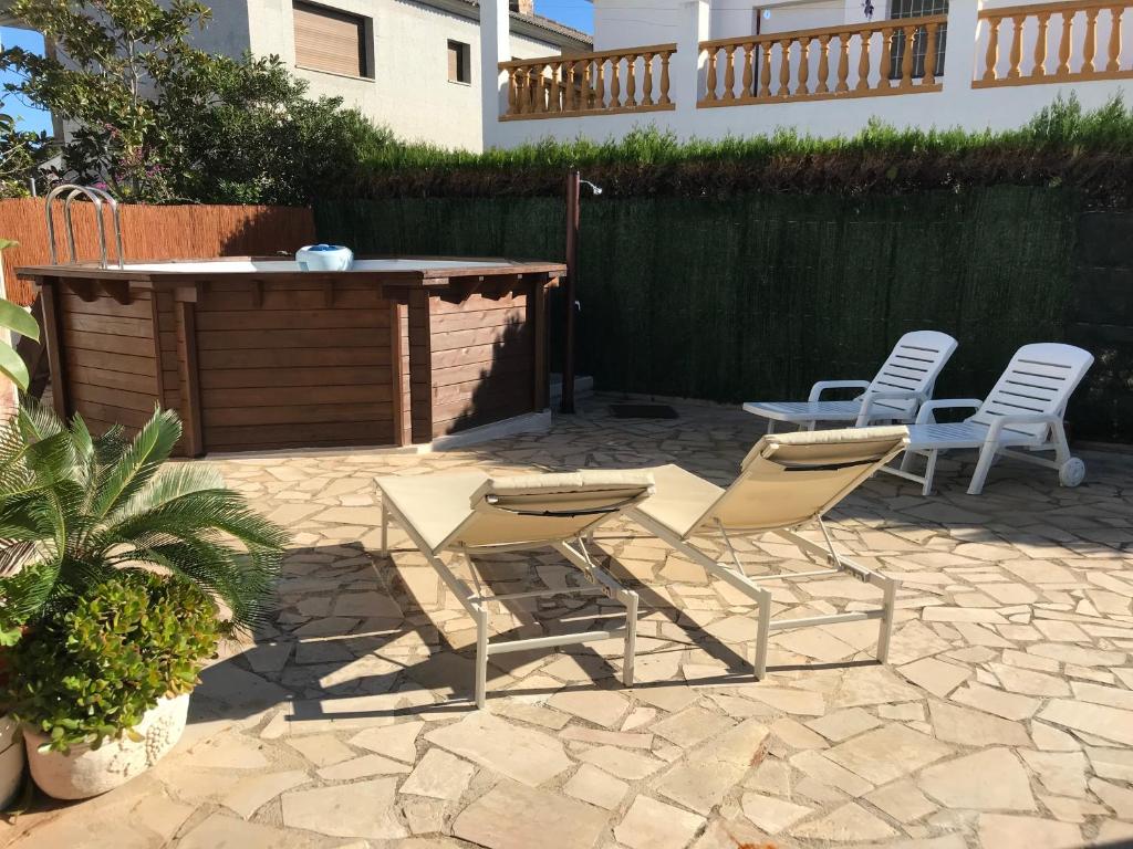 eine Terrasse mit Stühlen, einem Tisch und Stühlen in der Unterkunft La Casa de Papel in Alcanar