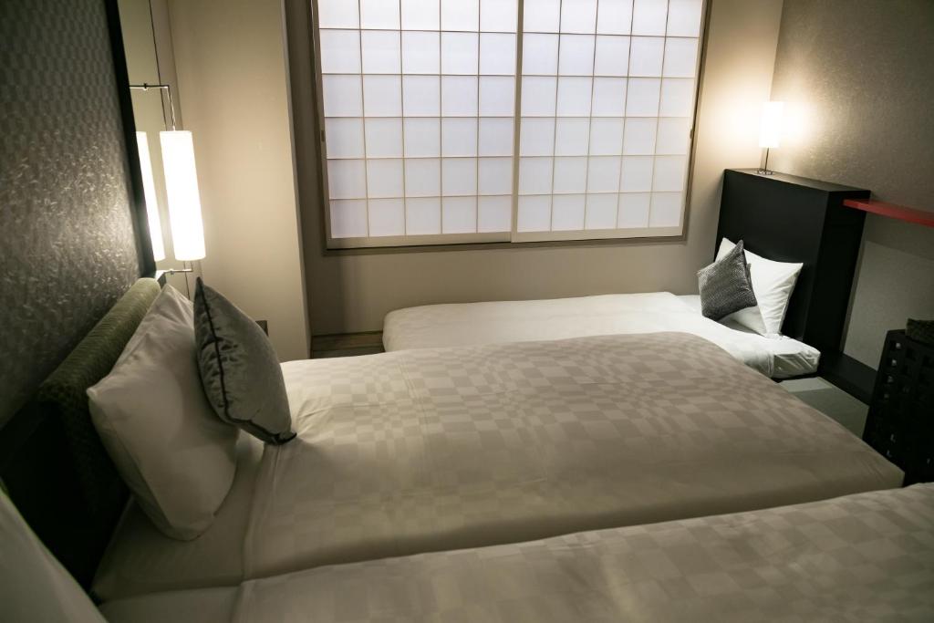 מיטה או מיטות בחדר ב-Hotel Resol Trinity Kyoto