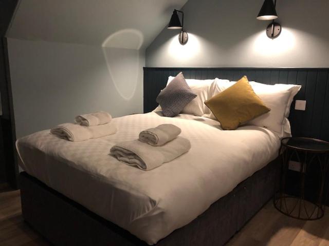 a bed with a white comforter and pillows at The Balavoulin in Aviemore