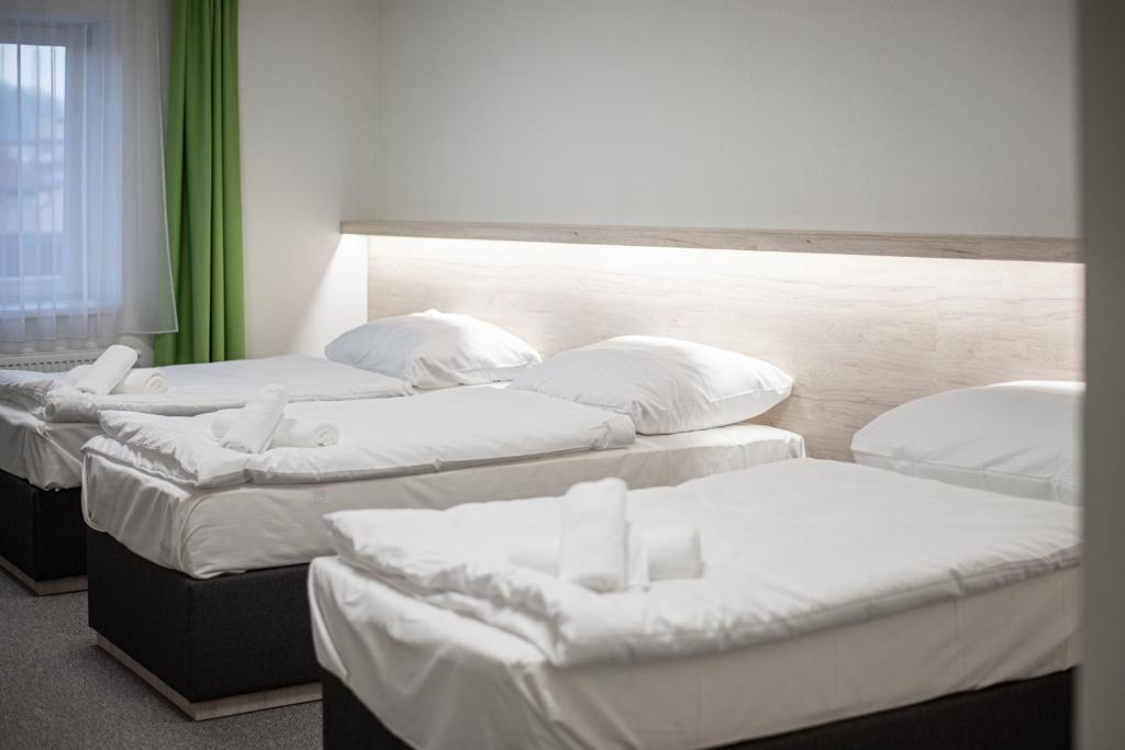 Postel nebo postele na pokoji v ubytování Garni hotel Roušarka