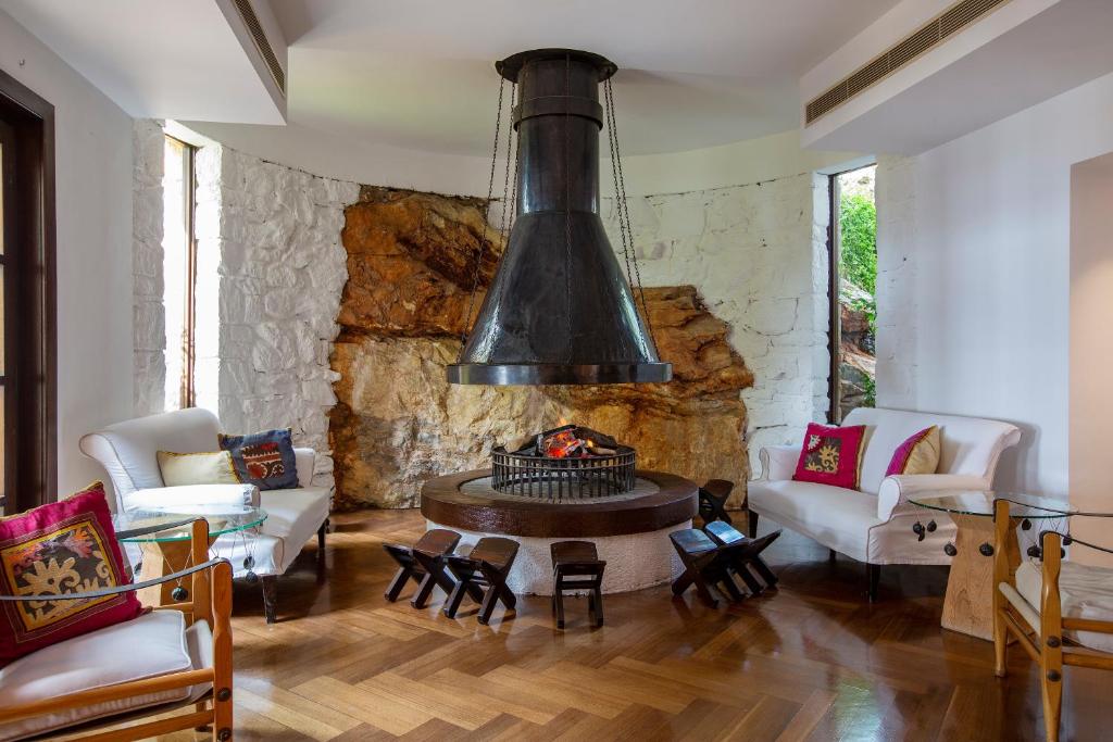 a living room with a stone wall and a fireplace at The Marmara Bodrum - Adult Only in Bodrum City