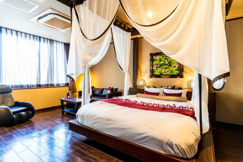 東京的住宿－Hotel Balian Resort Shinjuku Honten (Adult Only)，一间卧室配有一张带天蓬的床