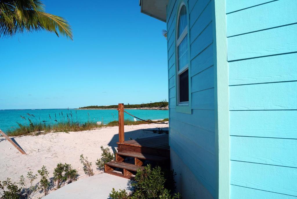 a blue house on the beach next to a beach at Paradise Bay Bahamas in Farmerʼs Hill