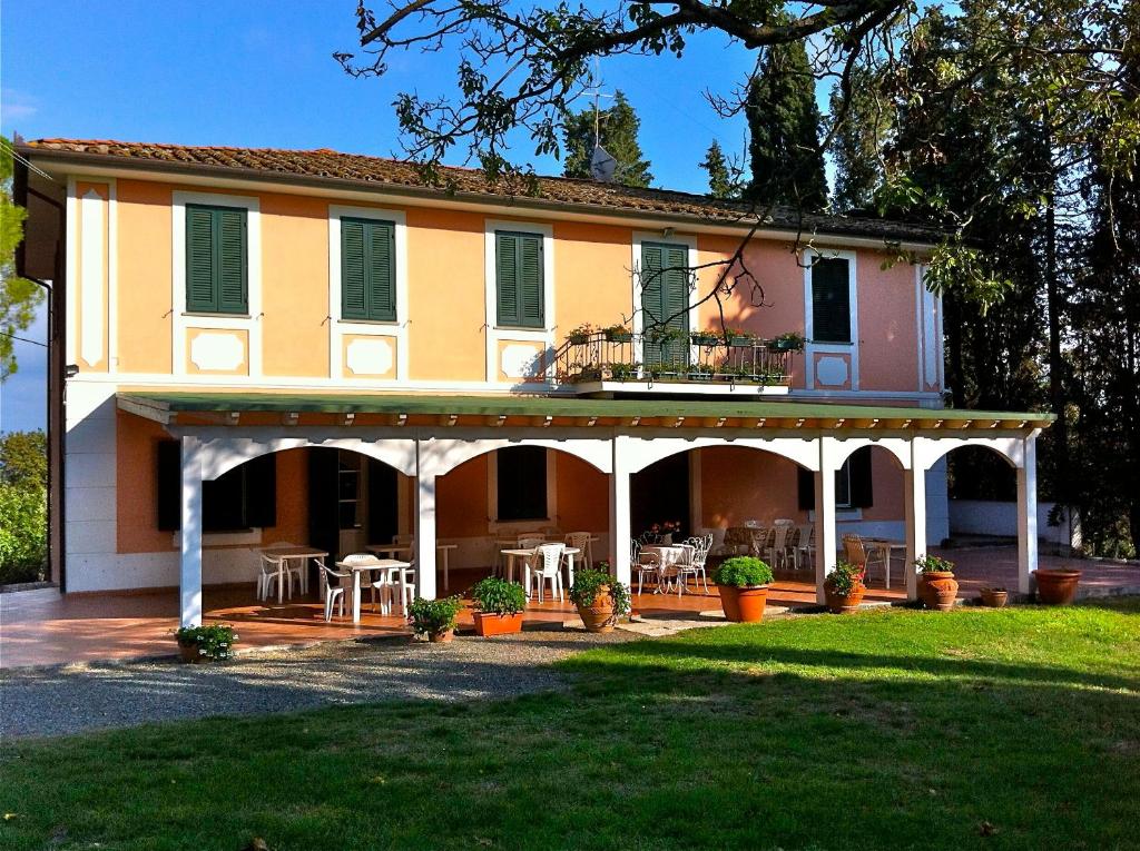 a large house with a porch with tables and chairs at Agriturismo Campo Al Sole in Castell’Anselmo