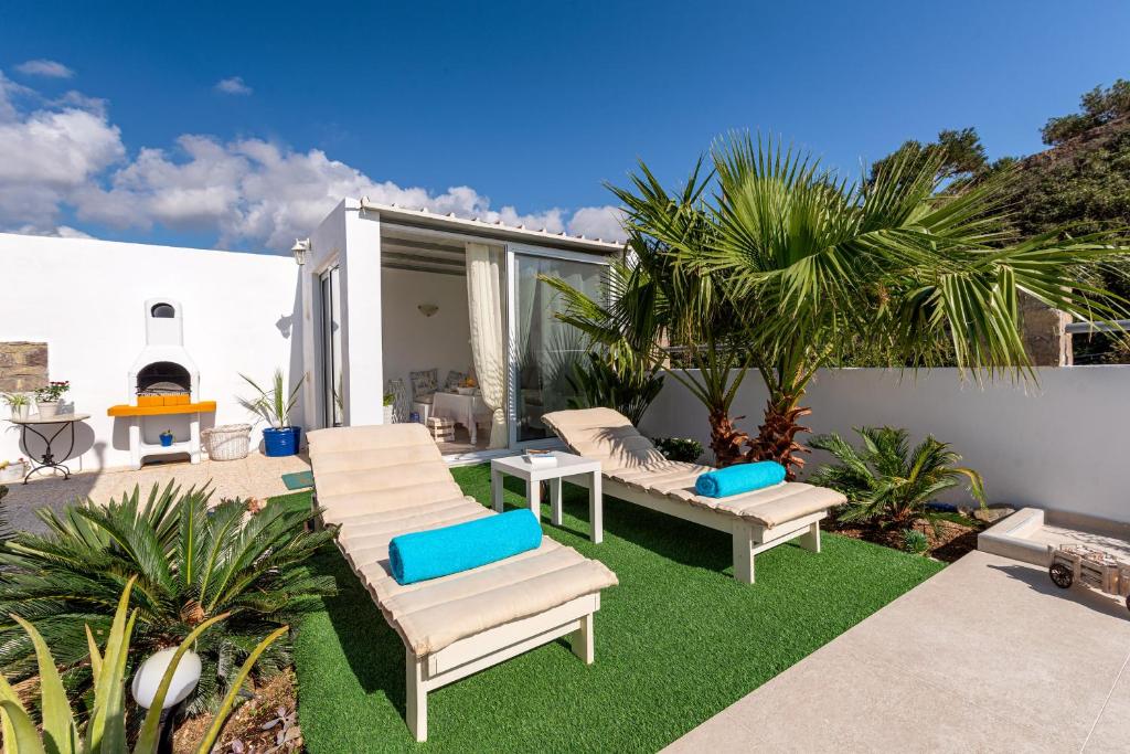 patio z leżakami i kominkiem w obiekcie Secret Paradise w mieście Koutsounari