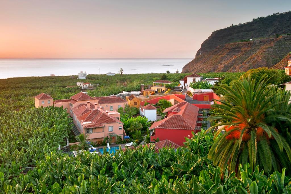 un pueblo en una colina con el océano en el fondo en Hotel Hacienda de Abajo-Adults Only-Lujo, en Tazacorte