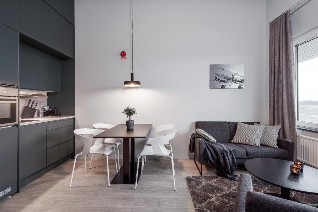 cocina y sala de estar con mesa y sofá en Forenom Hotel Arlanda, en Arlanda