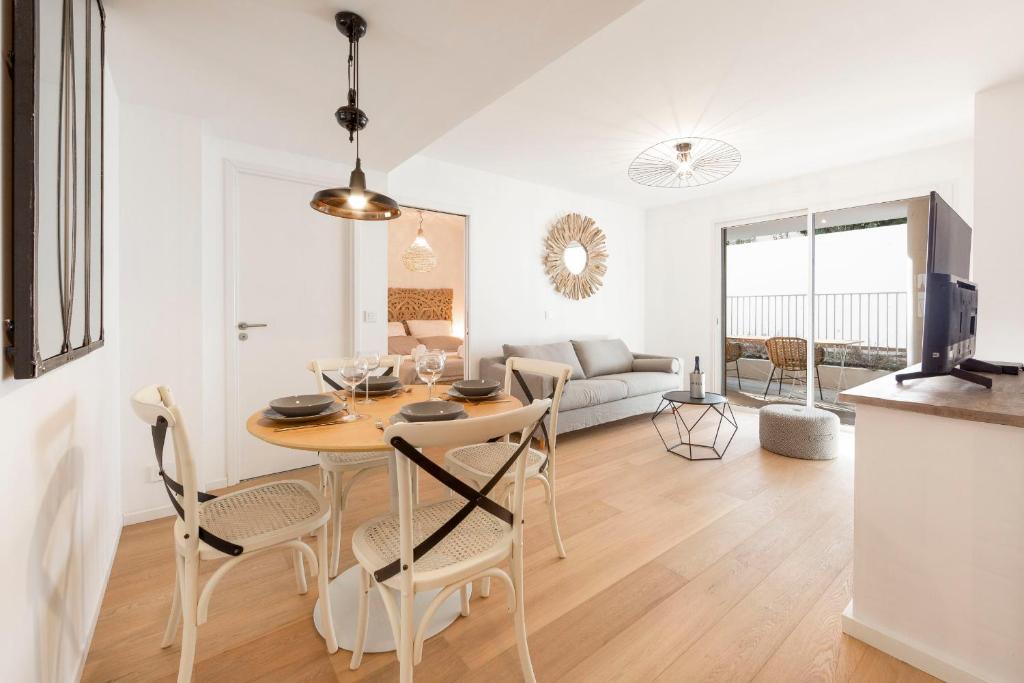 a kitchen and living room with a table and chairs at Les jardins secrets in Antibes