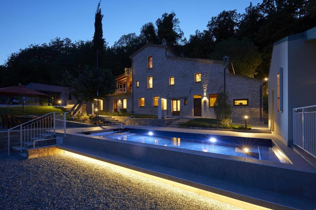 a house with a swimming pool at night at Appartamento Montale in Arcevia