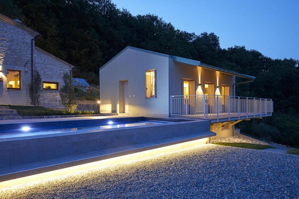 a house with a swimming pool at night at Appartamento Loretello in Arcevia