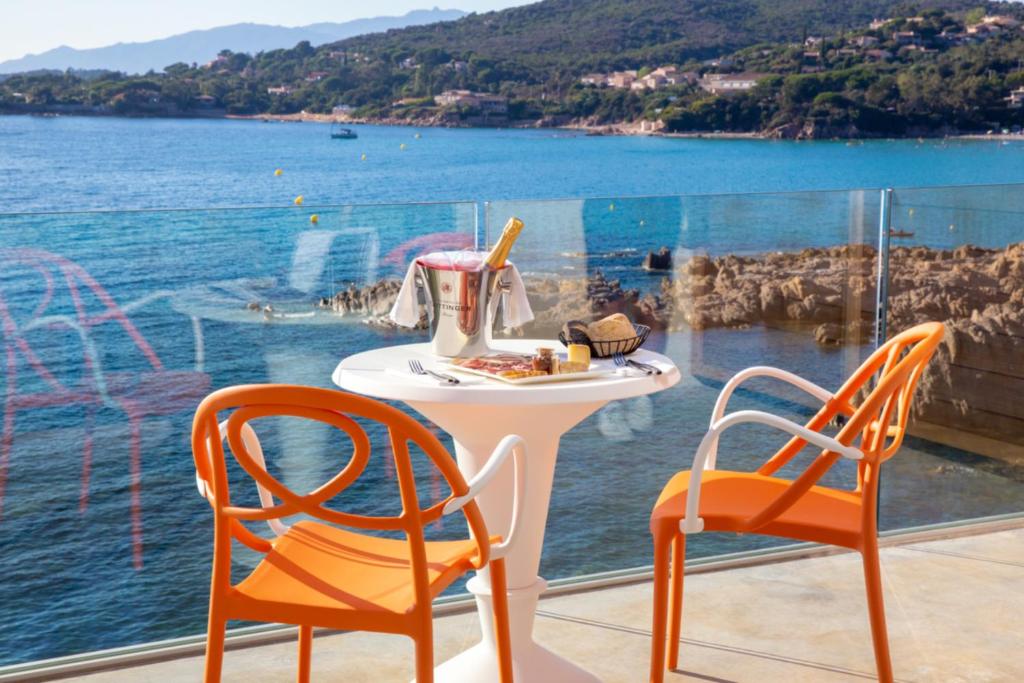 two chairs and a table with a tea pot on it at Hotel le Jardin d'Emile in Porticcio