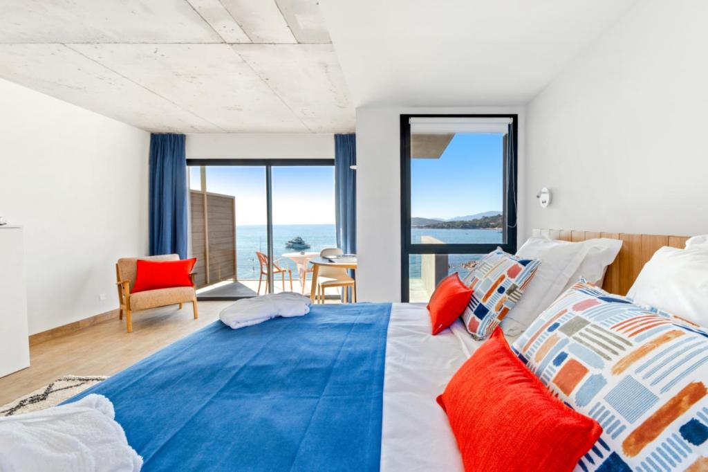 a bedroom with a large bed with colorful pillows at Hotel le Jardin d'Emile in Porticcio