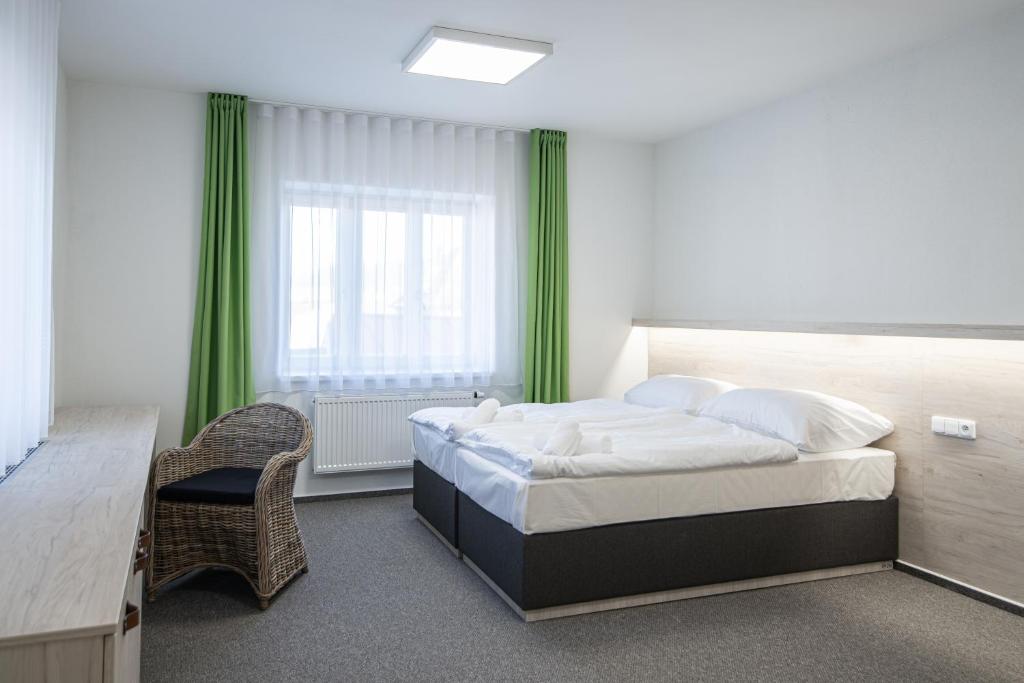 a bedroom with a large bed and a window at Garni hotel Roušarka in Sušice