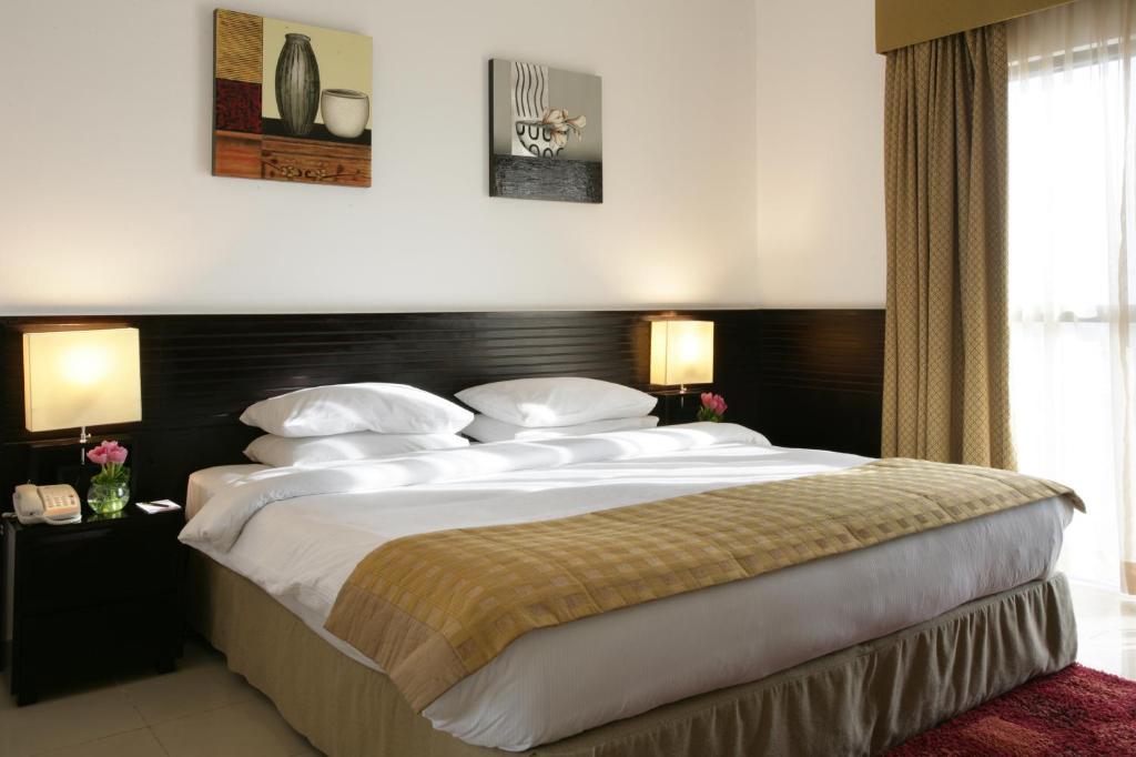 Una cama o camas en una habitación de Ramada Hotel & Suites by Wyndham Ajman