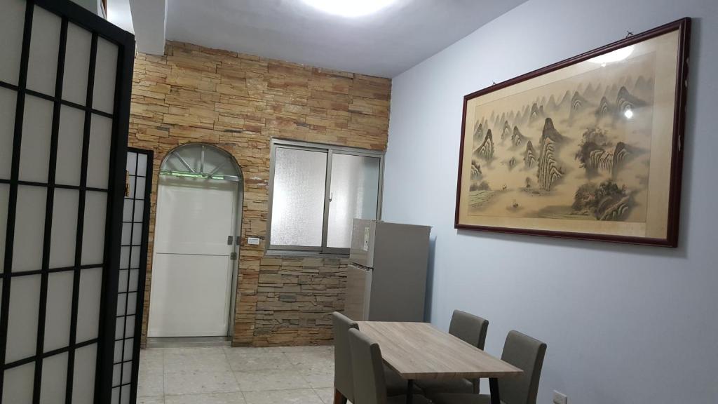 枋寮鄉的住宿－枋寮小象民宿，一间用餐室,配有一张桌子和一张墙上的照片